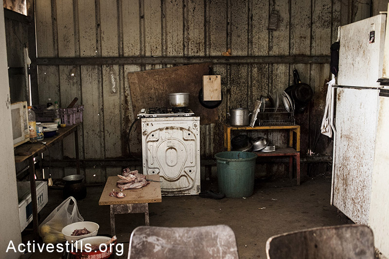 The kitchen inside a caravan used by four agriculture Thai workers, Moshav Yavetz, January 25, 2014. (Shiraz Grinbaum/Activestills.org)