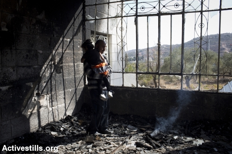 Khaled Abed a-Rahman Dar Khalil inspects the damage inside his home, which was torched by Jewish settlers, Sinjil, West Bank, November 14, 2013. Five children were treated for smoke inhalation. (Photo: Oren Ziv/Activestills.org)