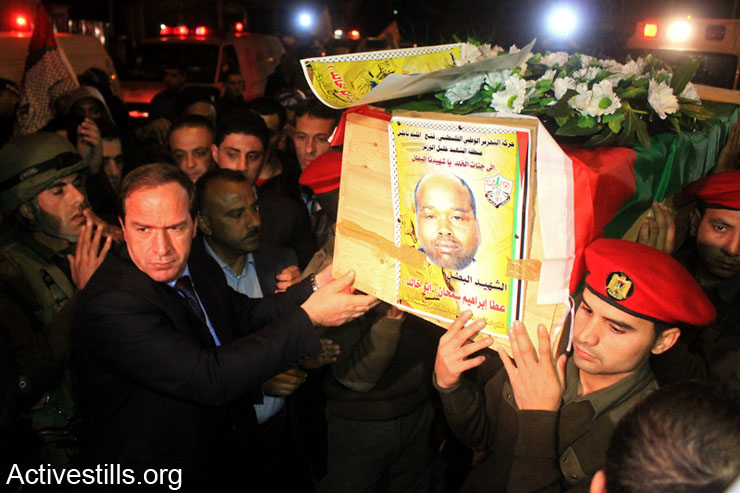 Palestinians receive the remains of two Palestinian fighters, Fathi Amerih and Atta Samahneh, in the West Bank city of Tulkarm, January 21, 2014. Amerih was killed by the Israeli army in 2002; Samahneh was killed in 2004. Israel still holds hundreds of Palestinian bodies in an isolated cemetery in the Jordan Valley, West Bank. (photo: Ahmad Al-Bazz/Activestills.org)