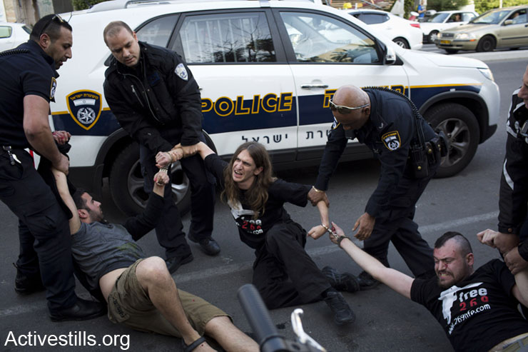 Israeli policemen arrest Israeli animal rights activists, from the 269_Life group, who took part in a direct action inside the offices of the Animal Farming Council, Tel Aviv, January 21, 2014. The activists placed dead chickens collected from 'Nordia' hatchery and spilled red paint inside the office. Nine activists were arrested by the Israeli police. (photo: Oren Ziv/Activestills.org)