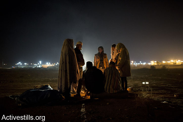African asylum seekers gather around the fire in the early morning of a second day of protest outside the Holot detention center where hundreds of Aylum seekers are jailed, February 18, 2014 in the southern Negev desert of Israel.