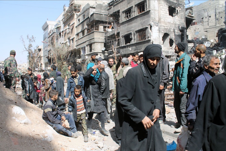 Gathered on Yarmouk Street, residents begin hurrying to reach the distribution point.’ (Photo by UNRWA)
