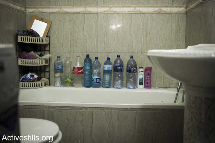 Plastic bottles line the Swetti family's shower, Ras Shehada neighborhood, East Jerusalem, March 15, 2014. The family of nine had gone 13 days without running water. (photo: Activestills.org)