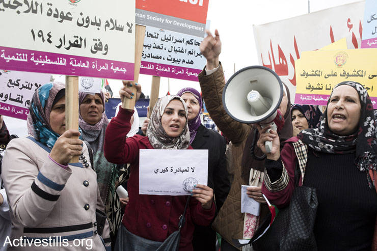 Women shout slogans during the International Women's Day march in Qalandiya, West Bank on March 8th, 2014. Around 400 women and supporters marched to the Israeli checkpoint holding signs and shouting slogans against the occupation, calling to boycott Israel. The demonstration was dispersed by Israeli forces with tear gas and shock grenades.
