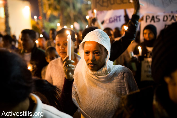 An African asylum seeker holding a candle during a March For Freedom, protesting against Holot detention centre located in Israel's south and the release of all refugees imprisoned under the Infiltrators Law, Tel Aviv, Israel, December 28, 2013. More than 5000 thousands African refugees participated in the march, supported by a few hundreds Israeli activists, all calling for recognition of all refugees rights.