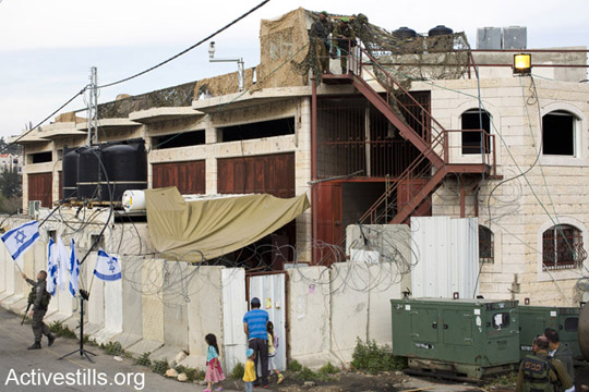 Jewish settler families move into the 'House of Contention' in Hebron, April 13, 2014 (Photo by Keren Manor/Activestills.org)
