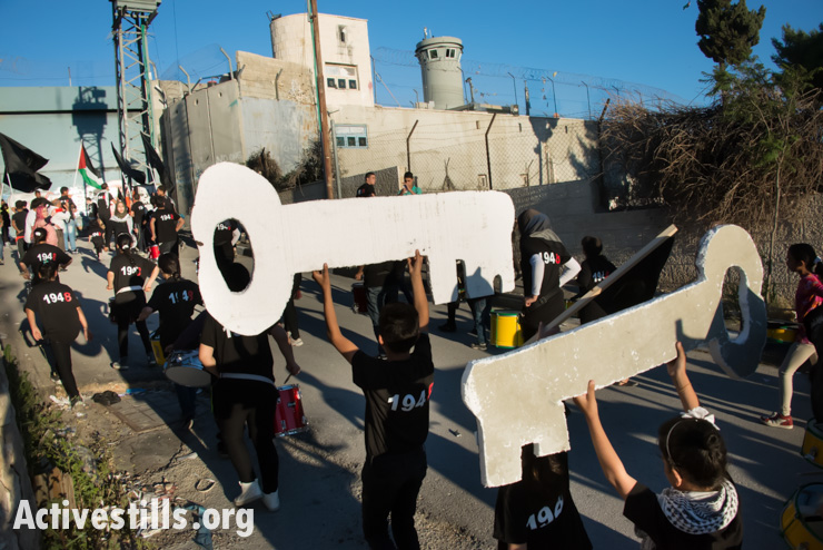 Children from Aida Refugee Camp carry keys symbolizing the right of return toward the Israeli separation wall during a Nakba commemoration event, Bethlehem, West Bank, May 14, 2014.