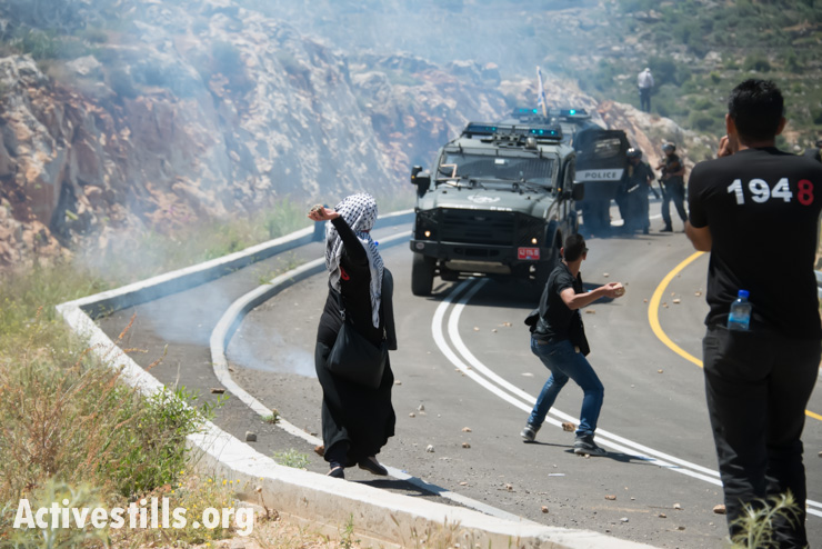 Palestinian youth throw stones at Israeli forces on the path of the Israeli separation barrier under construction on land belonging to the West Bank village of Al Walaja in a Nakba Day protest, May 15, 2014. As with 85% of its route, the separation wall is being built on Al Walaja land inside the West Bank, rather than on the internationally recognized border, or Green Line, with Israel.