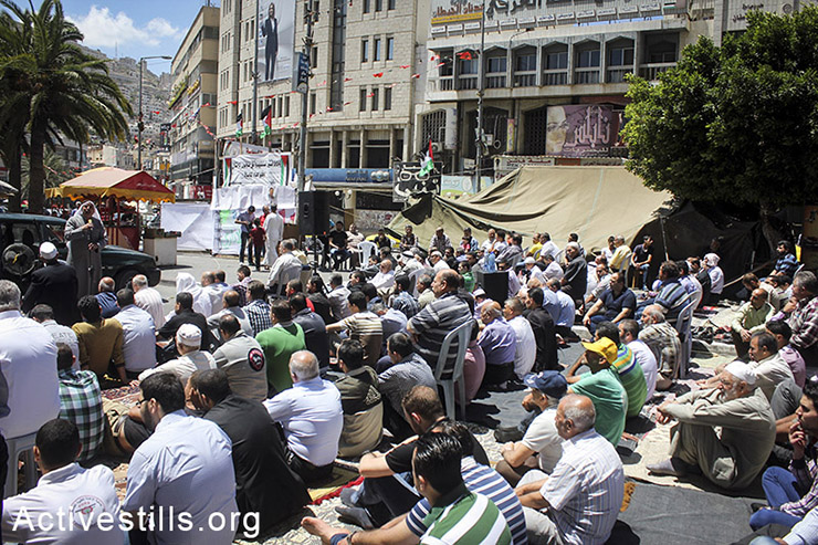 Palestinians participate in a Friday prayer near a protest tent in solidarity with  hunger-striking Palestinian administrative prisoners, Nablus, West Bank, May 02, 2014. (Ahmad al-Bazz/Activestills.org)