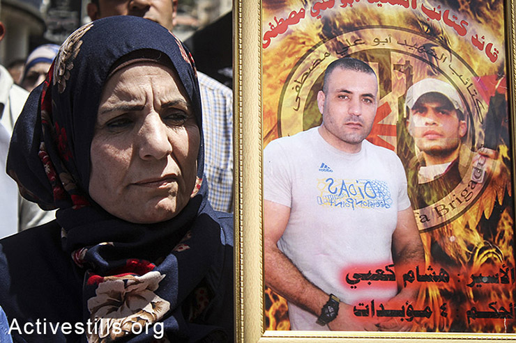 Hanaa kabi holds her brother's picture during a demonstration in solidarity with hunger-striking Palestinian administrative prisoners in Nablus city, West Bank, May 03, 2014. (Ahmad al-Bazz/Activestills.org)