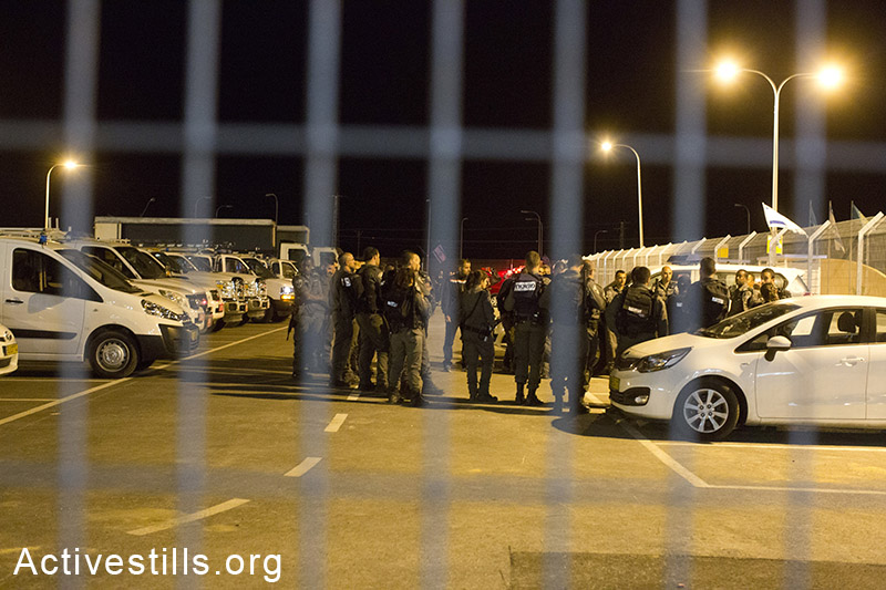 Police forces stand next to the entrance to Holot detention center, after a group of around 1000 African asylum seekers gathered for a solidarity demonstration, in support of some of their friends that spent the second night sleeping outside due to lack of beds. The protesters agreed to go back to their cells after a solution was found, Negev Desert, May 20, 2014. (Activestills.org)