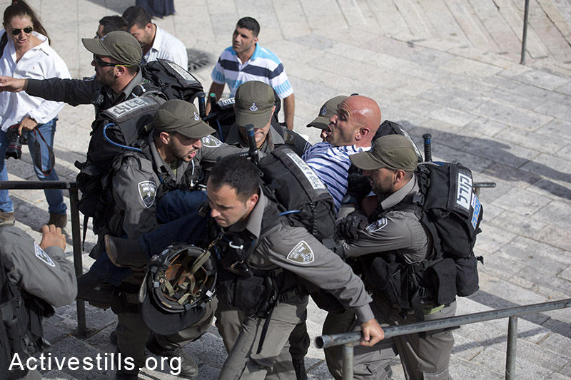 Israeli border policemen detain a Palestinian journalist before Israeli settlers and Ultra-nationalists take part in the 'flag march' through Damascus Gate in east Jerusalem, on May 28, 2014, celebrating the anniversary of its capture in the 1967 Six-Day War. Police prevented from Palestinians to gather and  protest against the march, and attacked journalists that were covering  the event. (Oren Ziv/Activestillsorg)
