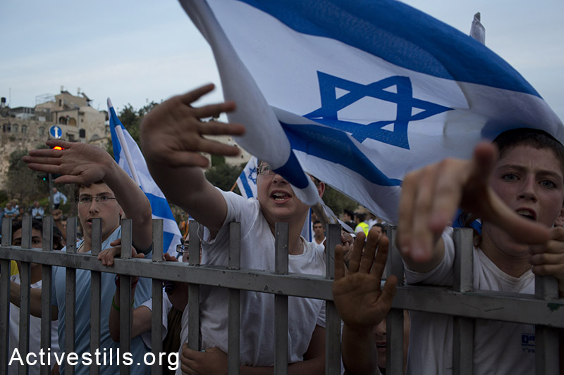 Israeli settlers and Ultra-nationalists take part in the 'flag march' through Damascus Gate in east Jerusalem, on May 28, 2014, celebrating the anniversary of its capture in the 1967 Six-Day War. Police prevented from Palestinians to gather and  protest against the march, and attacked journalists that were covering  the event. (Oren Ziv/Activestills.org)