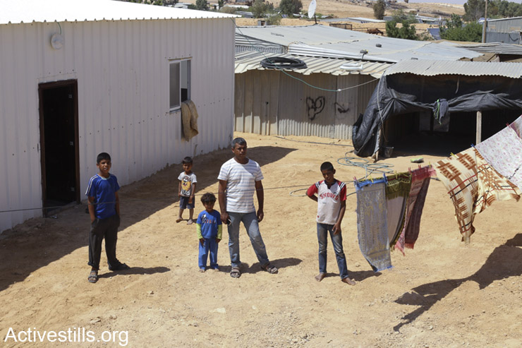 Eyad Adisan and his sons stand outside his home, which is in danger of being demolished. (photo: Keren Manor / Activestills.org)