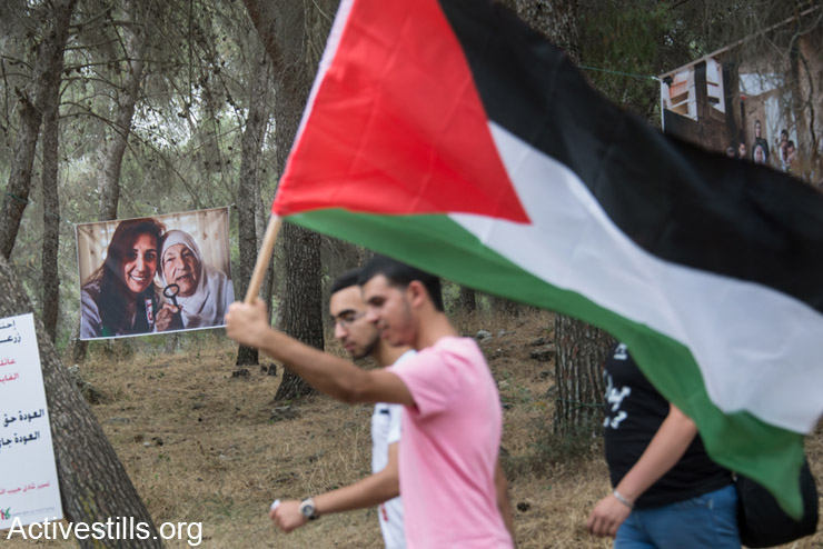Palestinian citizens of Israel pass photos of Palestinian refugees as they walk in the March of Return to the village of Lubya in northern Israel, May 6, 2014. Lubya was destroyed in the Nakba, literally "catastrophe", in which more than 500 Palestinian villages were destroyed before and during the 1948 War. 