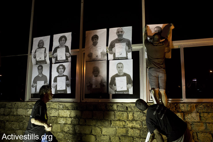 Israeli activists from "Zochrot" organization hang portraits of Israelis, holding a statement of recognition of the Palestinian Nakba, on the 1948 headquarters of the "Irgon", located in the area of the destroyed Palestinian village of Manhyia, near the city of Jaffa, May 5th, 2014.The action was held on the evening of the Israeli Independence day to commemorate the Palestinian 1948 Nakba.