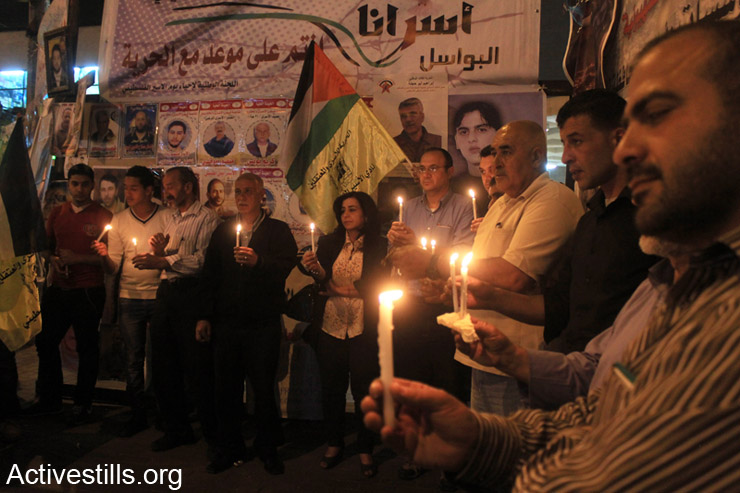 Palestinians hold candles during a protest in solidarity with hunger-striking Palestinian administrative prisoners, Nablus, West Bank, May 3rd, 2014. More than 100 Palestinian administrative prisoners in Israeli prisons launched a mass, open-ended hunger strike on Thursday, April 24, 2014, at the Ofer, Megiddo, and Negev prisons. The strike came after Israeli authorities reneged on a promise to limit the use of administrative detention to exceptional cases.