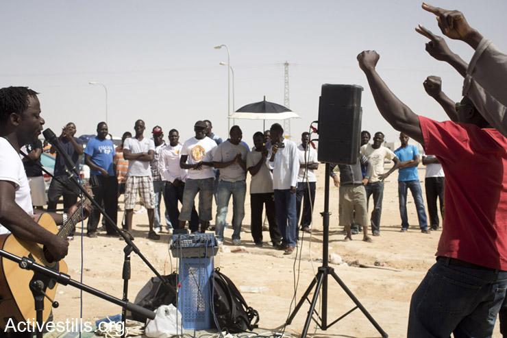 African asylum seekers dance at a live concert during a solidarity visit of Israeli and African activists outside the Holot detention center, Negev Desert, May 3, 2014.
