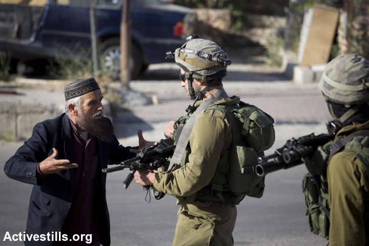 An elderly Palestinian man argues with an Israeli soldier taking part in the search operation for three Israeli teenagers believed to have been kidnapped by Palestinian militants, on June 17, 2014 in the West Bank city of Hebron. Israel stepped up efforts against Hamas in the West Bank Tuesday as the hunt for three Israeli teenagers entered its fifth day. (Photo: Oren Ziv/Activestills.org)