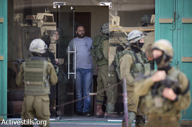 Israeli soldiers from a special army unit take part in a search operation raid a Palestinian shop in the West Bank town of Hebron. June 18, 2014 (Oren Ziv/Activestills.org)
