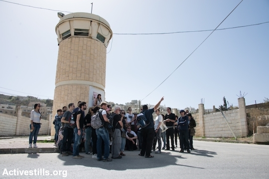 Yehuda Shaul of the Israeli activist group Breaking the Silence leads a tour group on Shuhada Street in the West Bank city of Hebron, March 7, 2014. (Photo: Ryan Rodrick Beiler/Activestills.org)