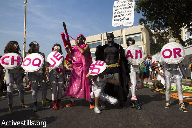 Activists take part in a demonstration against the world cap also marking 45 years to the Stone Wall attack, June 28, 2014. "Choque de amor"- choque is the police anti protest troops. letters means: "troops of love".  (Keren Manor/Activestills.org)  