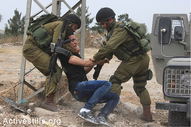 Israeli soldiers arrest a Palestinian man during the 'Return March,' held alongside the separation wall near Tulkarem, West Bank, May 31, 2014.