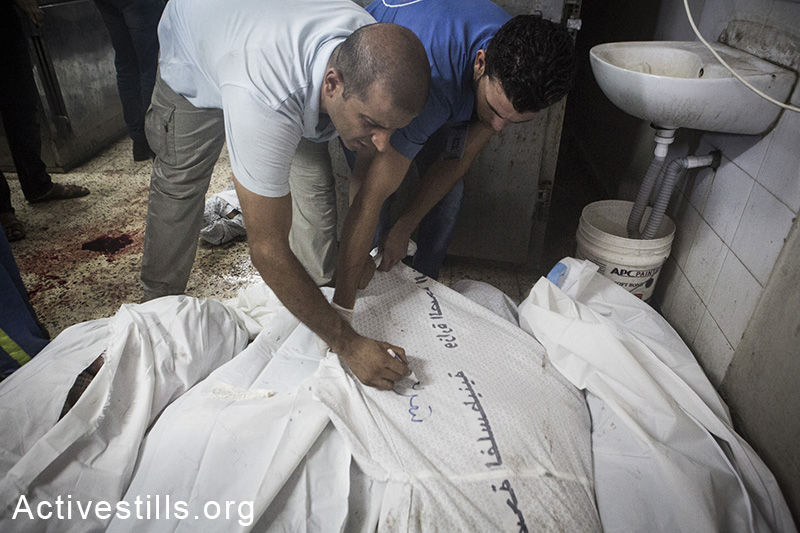Hospital workers tend to dead bodies at Shifa Hospital, July 20, 2014 (photo: Anne Paq/Activestills.org)