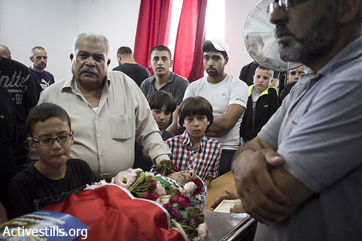 Family members and friends mourn next to the body of killed Palestinian Mohammed al-Araj during his funeral at the Qalandiya refugee camp near the West Bank city of Ramallah, on July 25, 2014. Al-Araj was shot with live ammunition in his head during a demonstration the night before in Qalandiya. At least other 500 Palestinians were injured from live ammunition, some of them are still under critical condition. (Oren Ziv/Activestills.org)