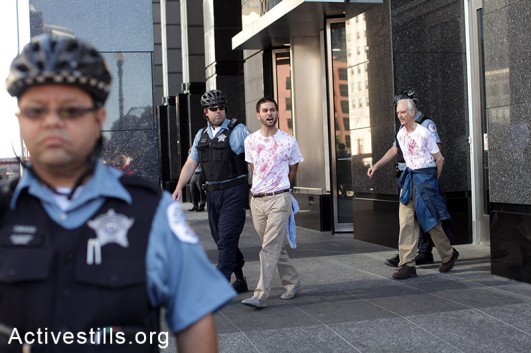Five activists were arrested during a direct action at Boeing International Headquarters in Downtown Chicago on July 16, 2014. The activists wore red stained shirts and protested Boeing's involvement in the deaths of Palestinians during the recent Israeli offensive in Gaza. (Tess Shcaflan/Activestills.org)