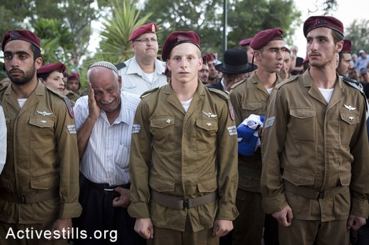 Soldiers and relatives mourn at the grave of Israeli Sergeant Banaya Rubel during his funeral on July 20, 2014 in Holon, Israel. Sergeant Rubel was killed along with another Israeli army soldier on the twelfth day of operation 'Protective Edge,' when Hamas militants infiltrated Israel from a tunnel dug from Gaza and engaged Israeli soldiers. (Oren Ziv/Activestills.org)