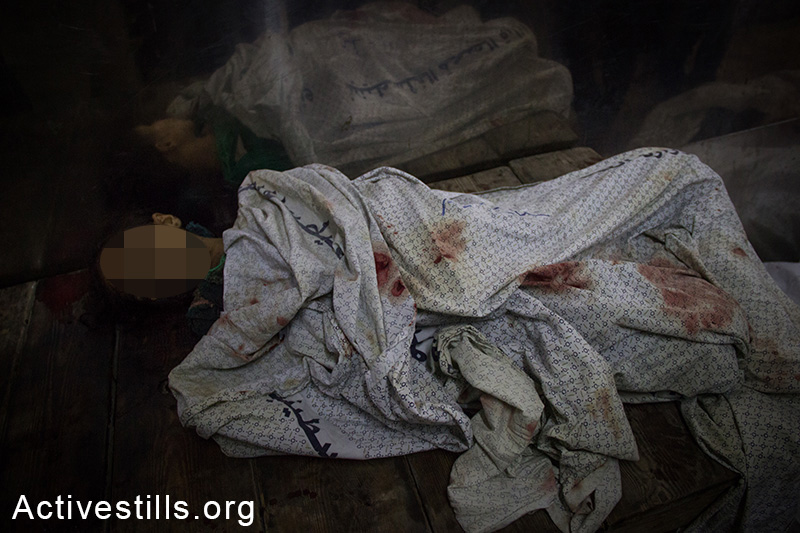 The body of a young girl lays at the Shifa Hospital, July 20, 2014. (Basel Yazouri/Activestills.org) 