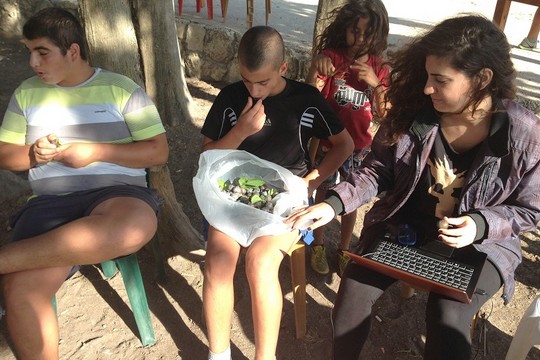 Children in Bir'im eat 'Arsia,' a type of fruit native to the village. (photo: by Eitan Bronstein Aparicio)