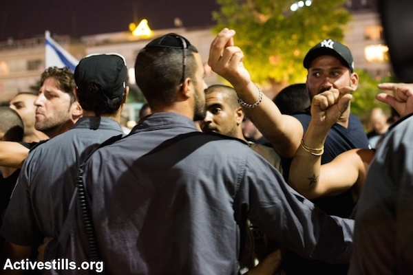 Police stopping right-wing nationalists from attacking left wing activists during a protest in central Tel Aviv against the Israeli attack on Gaza, July 12, 2014. The protest ended with the nationalists attacking a small group of left-wing activists with little police interference. (Photo by Yotam Ronen/Activestills.org)
