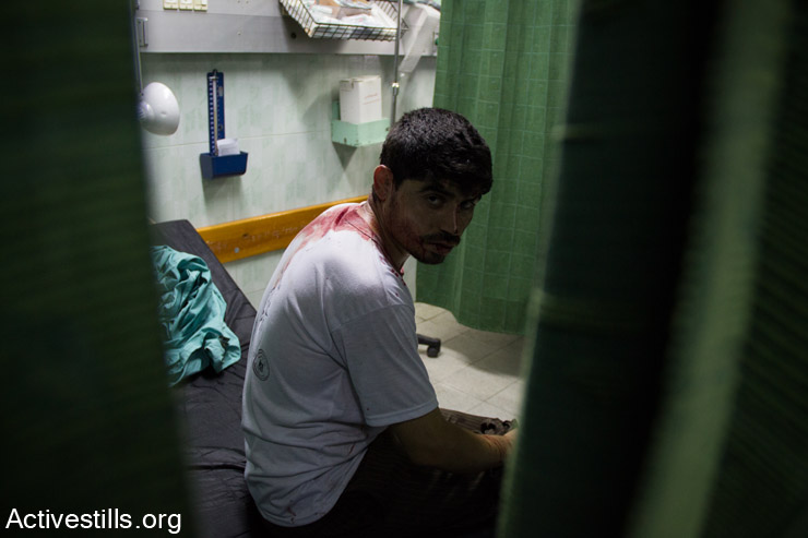 An injured Palestinian is seen in the emergency room of Kamal Edwan Hospital after an Israeli attack on Beit Hanoun elementary school, Jabalyia, Gaza Strip, July 24. The school was being used as a shelter by 800 people. The attack killed at least 17 and injured more than 200 of the displaced civilians. (Basel Yazouri/Activestills.org)