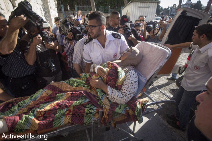 A Palestinian woman from the Gaza Strip arrives to the Saint Joseph hospital in East Jerusalem, on July 29, 2014 after she was injured in an Israeli military attack on Gaza. Israel exceptionally authorised around 50 Palestinians to cross into Israel to receive a specialized brain surgery following negotiations between the Red Cross and The Palestinian Authority. (Faiz Abu Rmeleh/Activestills.org)