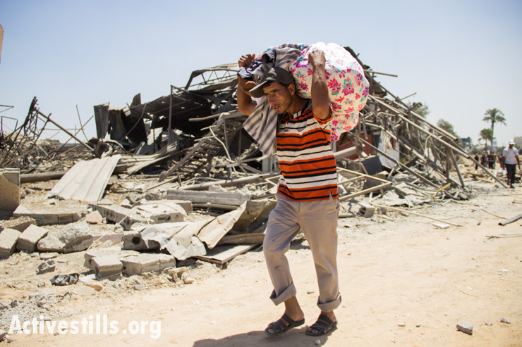Palestinians recover belongings from the Khuza'a neighborhood following bombardment by Israeli forces, Gaza Strip, August 1, 2014. 