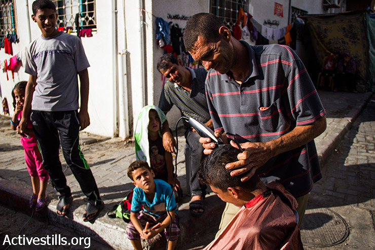 Gazans who evacuated their houses to find emergency shelter try to go on with the activities of daily life, Al-Shifa Hospital, August 9, 2014.  (Basel Yazouri/Activestills.org)