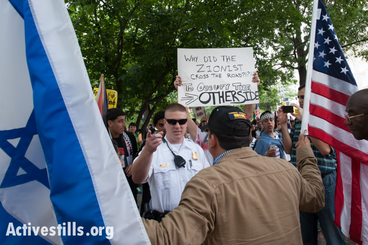 A policeman separates a pro-Israel counter-demonstrator from those marching to protest Israel's attack on Gaza, Washington, D.C., to protest against U.S. support for Israel's offensive in Gaza, August 2, 2014. So far, Israeli attacks have killed at least 1,622 Palestinians, the majority of them civilians, including 326 children.