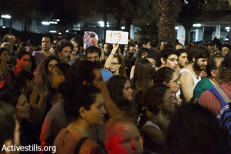 Left wing activist holds sign reads" "Stop" during a demonstration against the Israeli attack on Gaza, in center Tel Aviv, August 2, 2014. Police arrested 17 left wing protesters as hundreds gathered outside Habima theatre calling to end the attack on Gaza. (Keren Manor/Activestills.org)