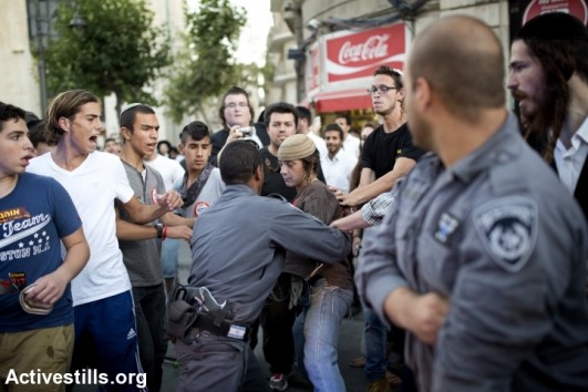 Right-wing protesters shouting slogans at Palestinians during riots that irrupted following the finding of the bodies of three teenaged settlers near Halhul, West Jerusalem, July 1st, 2014. The riots broke during the funerals of Eyal Yifrah, 19, Gilad Shaar, 16, and Naftali Fraenkel, 16-year-old, that were kidnapped and killed in the West Bank. A few right-wing persons were arrested during the riots. (Tali Mayer/Activestills.org)