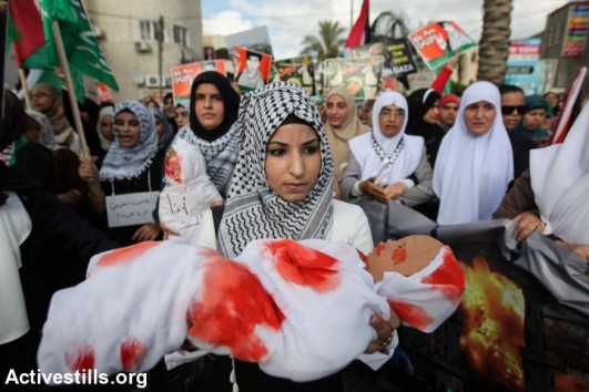 Palestinian women living in Israel hold dolls wrapped in a white cloth, during a demonstration against the Israeli attack on Gaza and in support of the Palestinian people, in the northern village Tamra on August 2, 2014 (photo: Activestills)