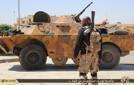 A fighter from the Islamic State stands in front of a tank. (photo: Islamic State)