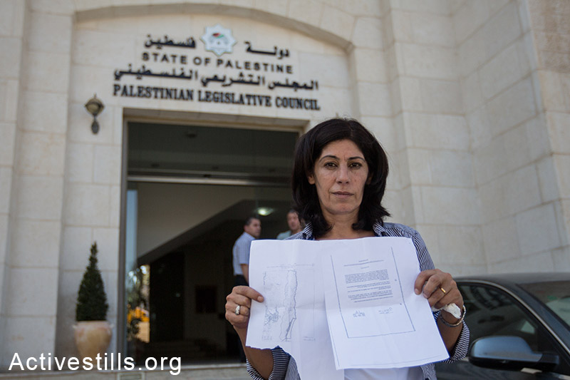 Khalida Jarrar, a member of the Palestinian Legislative Council, leader in the Popular Front for the Liberation of Palestine and longtime advocate for Palestinian political prisoners, showing an internal expulsion order given to her by Israeli soldiers who invaded her home in Ramallah at 1:30 am on August 20, 2014, ordering her leave Ramallah to Jericho within 24 hours. (Activestills.org)