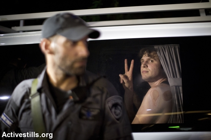 A leftist demonstrator looks on after being arrested by police during an anti-war demonstration in Tel Aviv. (photo: Keren Manor/Activestills.org)