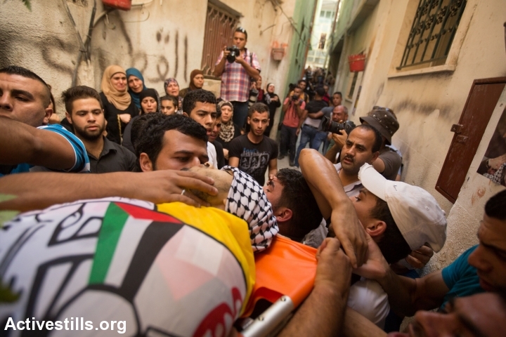 The funeral procession for Eissa al-Qotri at the Al-Amari refugee camp near the West Bank city of Ramallah, September 10, 2014. Al-Qotri was killed by the Israeli army early on September 10, 2014 during clashes between Palestinians and Israeli soldiers after the Israeli army raided the camp. (photo: Faiz Abu Rmeleh/Activestills)