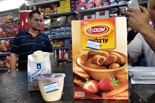 Stickers mark Israeli goods at a grocery store in Ramallah. (Photo by Jessica Devaney/Just Vision)