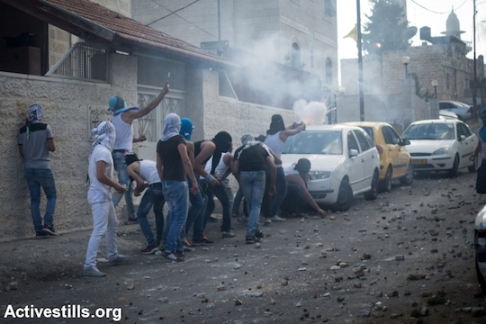 Palestinians throw stones at Israeli policemen during a protest following the death of a Palestinian teenager, in the East Jerusalem neighborhood of Wadi Joz, September 7, 2014. Mohammed Sunuqrut, 16, was wounded by police gunfire in the Wadi Joz neighborhood on August 31 and died from injuries on September 7. (Photo by Faiz Abu Rmeleh/Activestills.org)