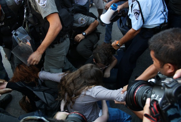 An Israeli Protester has her Hair Pulled by a Police Officer in Silwan. Photo by Joseph Dana