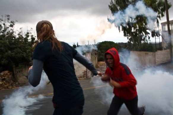 Palestinian Youth Flee Tear Gas in Nabi Saleh. Photo: Joseph Dana